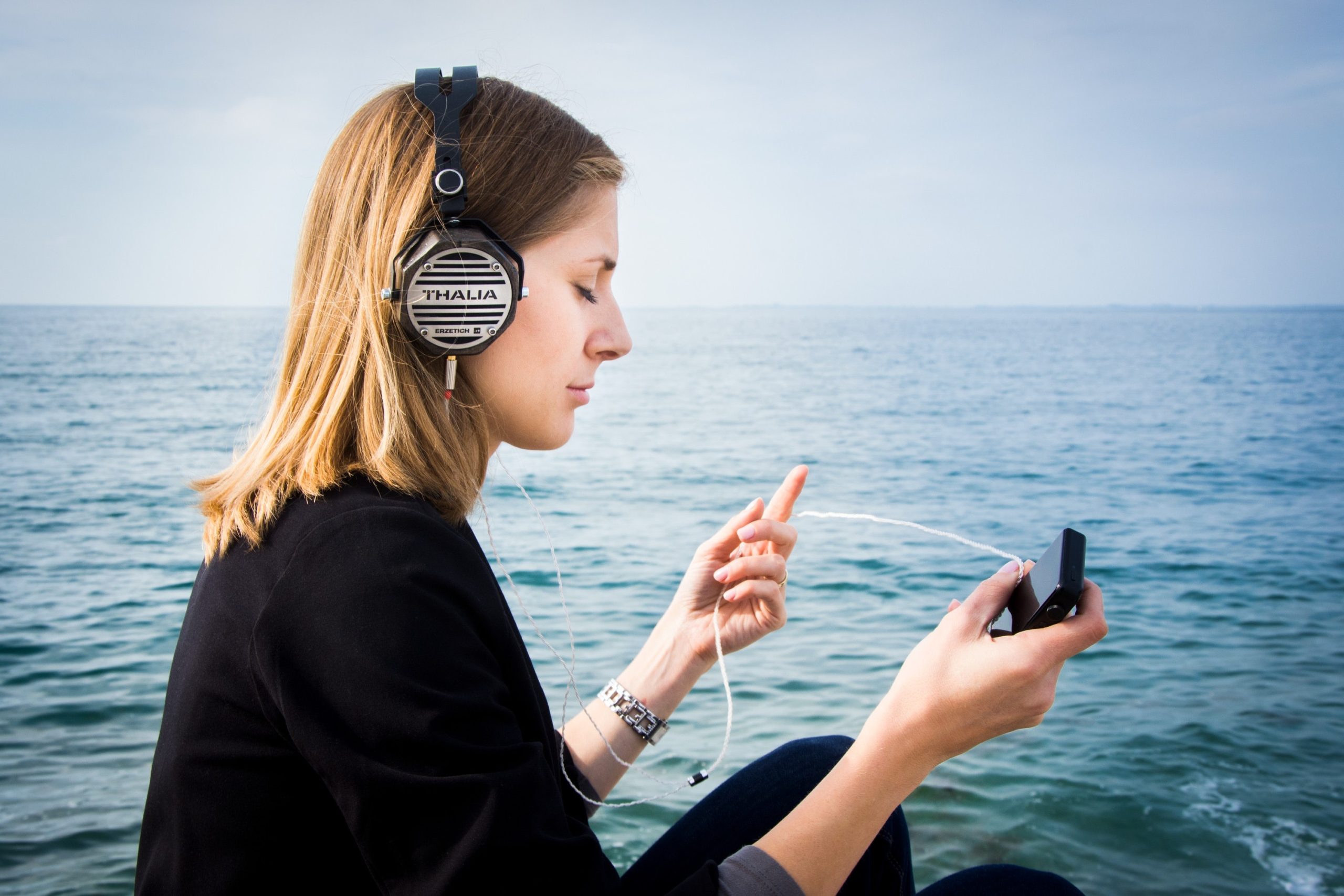 Woman wearing headphones by the sea